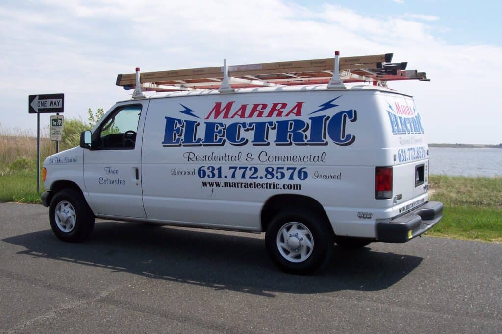 White Marra Electric service van with ladders on the roof, parked near a waterfront with visible branding and contact info in Suffolk County, NY.